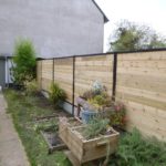 Installation d'une palissade écran de jardin composée de piquets métalliques, soubassement de bé...